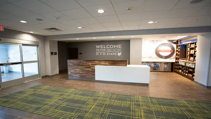 Hotel lobby. Check in desk in front of a wall that reads Welcome to the Buckeye State.